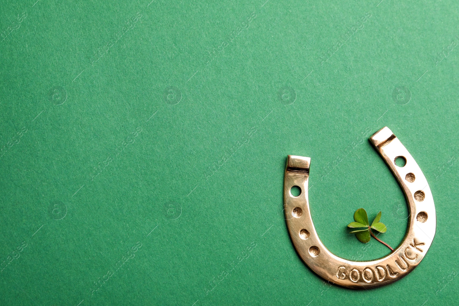 Photo of Flat lay composition with horseshoe on green background, space for text. St. Patrick's Day celebration