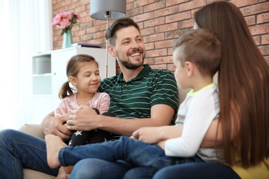 Photo of Young happy family with cute children at home