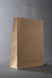 Photo of One kraft paper bag on grey background. Mockup for design