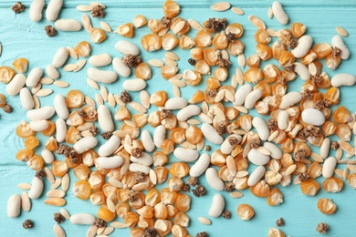 Photo of Mixed vegetable seeds on light blue wooden background, flat lay
