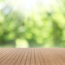 Image of Empty wooden surface against blurred green background. Bokeh effect