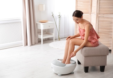 Photo of Woman with beautiful legs using foot bath at home, space for text. Spa treatment