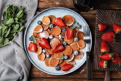 Photo of Cereal pancakes with berries served on wooden table, flat lay