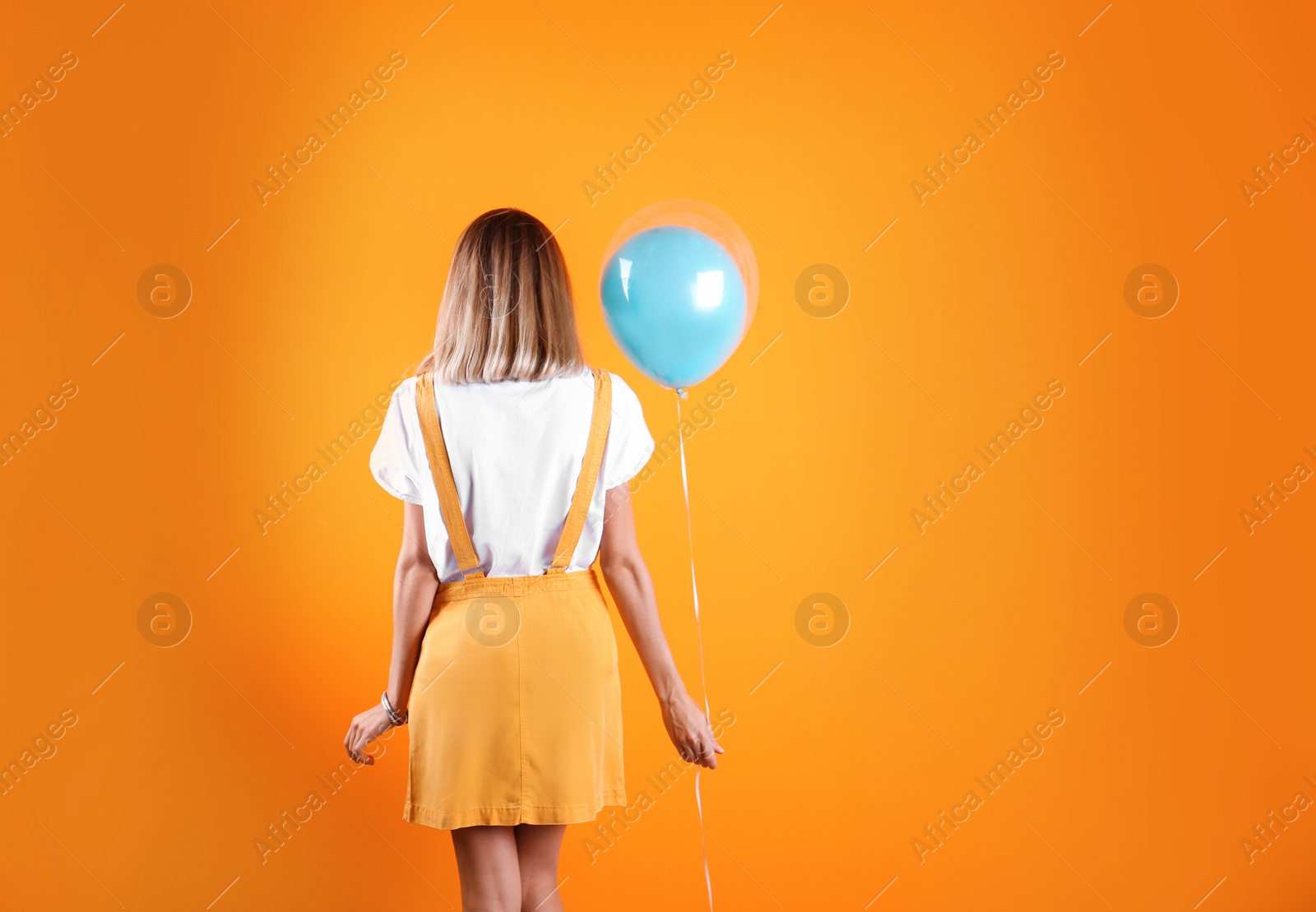 Photo of Young woman with air balloon on color background