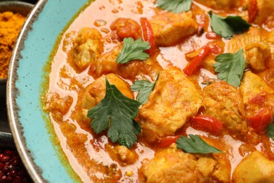 Photo of Delicious chicken curry with parsley on table, closeup