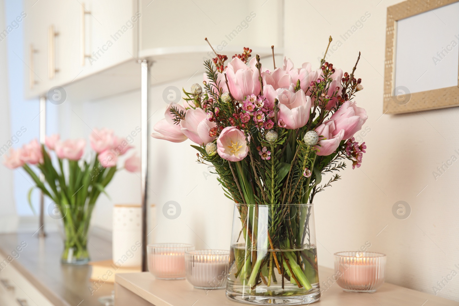 Photo of Beautiful bouquet with spring pink tulips on table indoors. Space for text