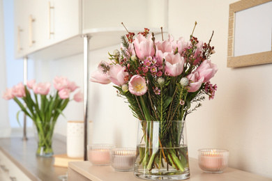 Photo of Beautiful bouquet with spring pink tulips on table indoors. Space for text