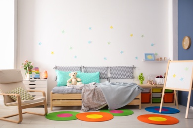 Photo of Modern child room interior with comfortable bed and armchair