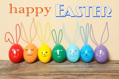 Image of Happy Easter. Colorful eggs as bunnies on wooden table against beige background