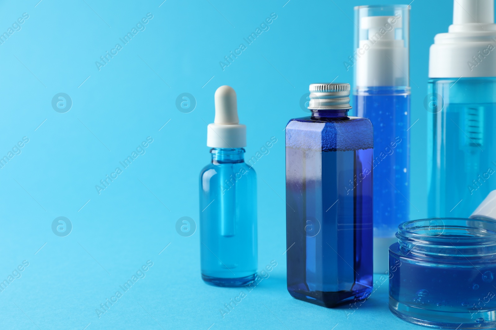 Photo of Set of luxury cosmetic products on light blue background. Space for text