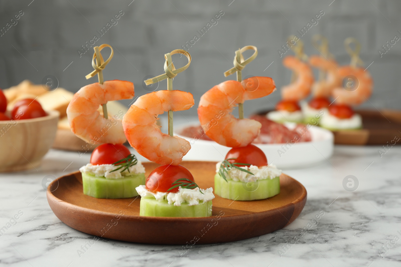 Photo of Tasty canapes with shrimps, vegetables and cream cheese on white marble table, closeup