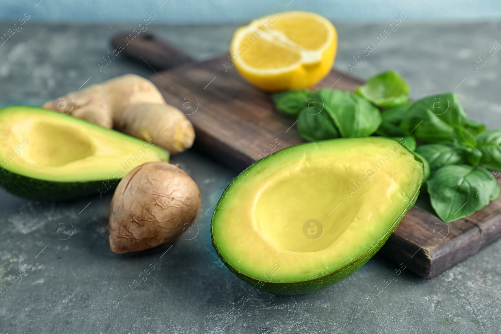 Photo of Composition with ripe avocado and basil on grey table