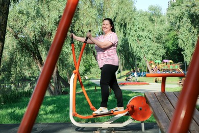 Photo of Overweight woman doing exercise with air walker in park