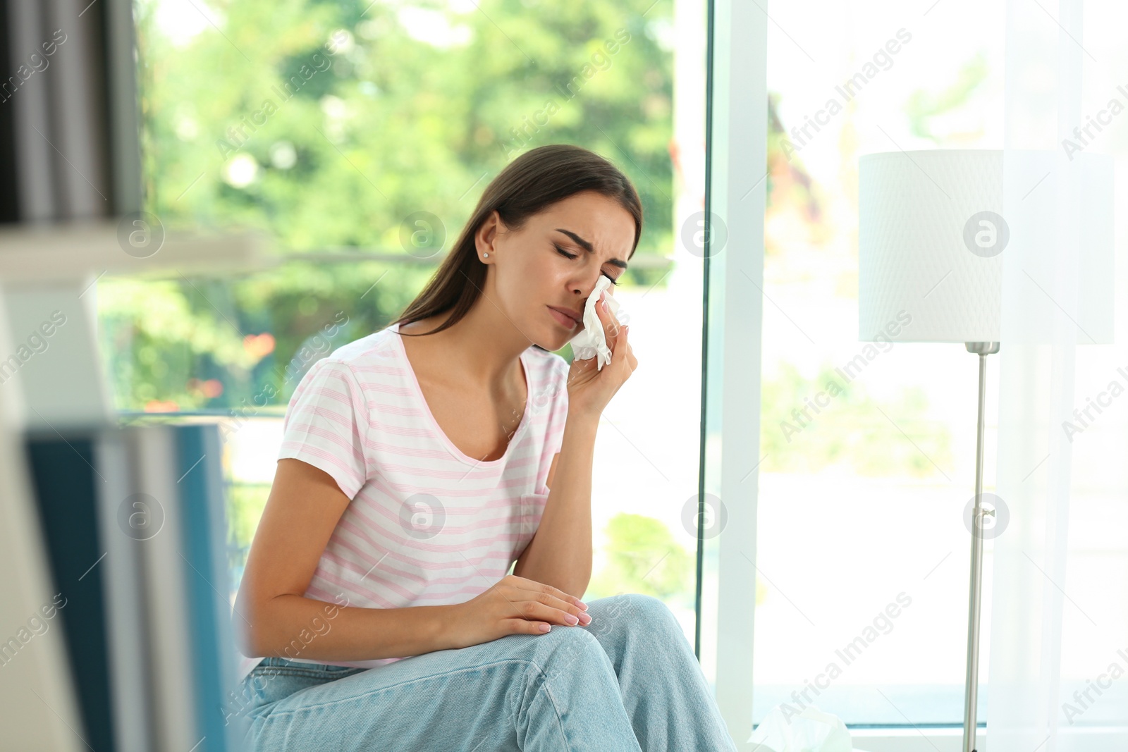 Photo of Young woman suffering from allergy at home