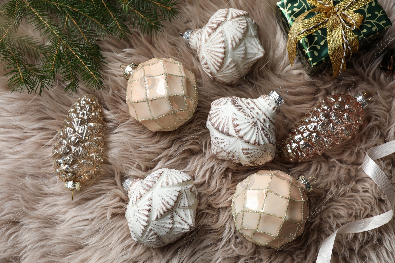 Photo of Flat lay composition with beautiful Christmas baubles on beige fur