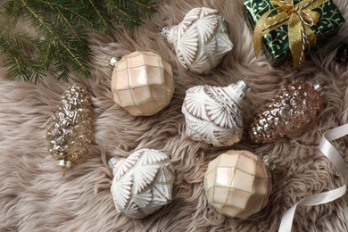 Flat lay composition with beautiful Christmas baubles on beige fur