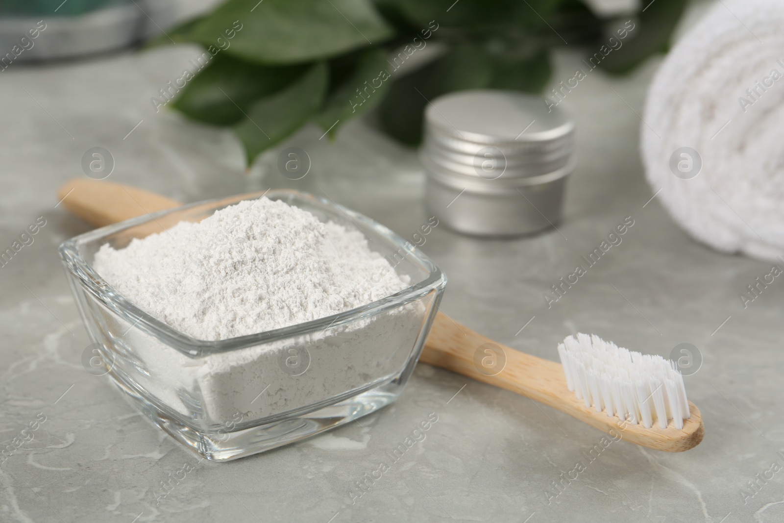 Photo of Tooth powder and brush on light grey marble table, closeup