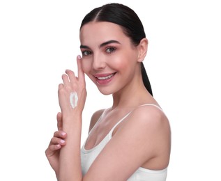 Beautiful woman with smear of body cream on her hand against white background