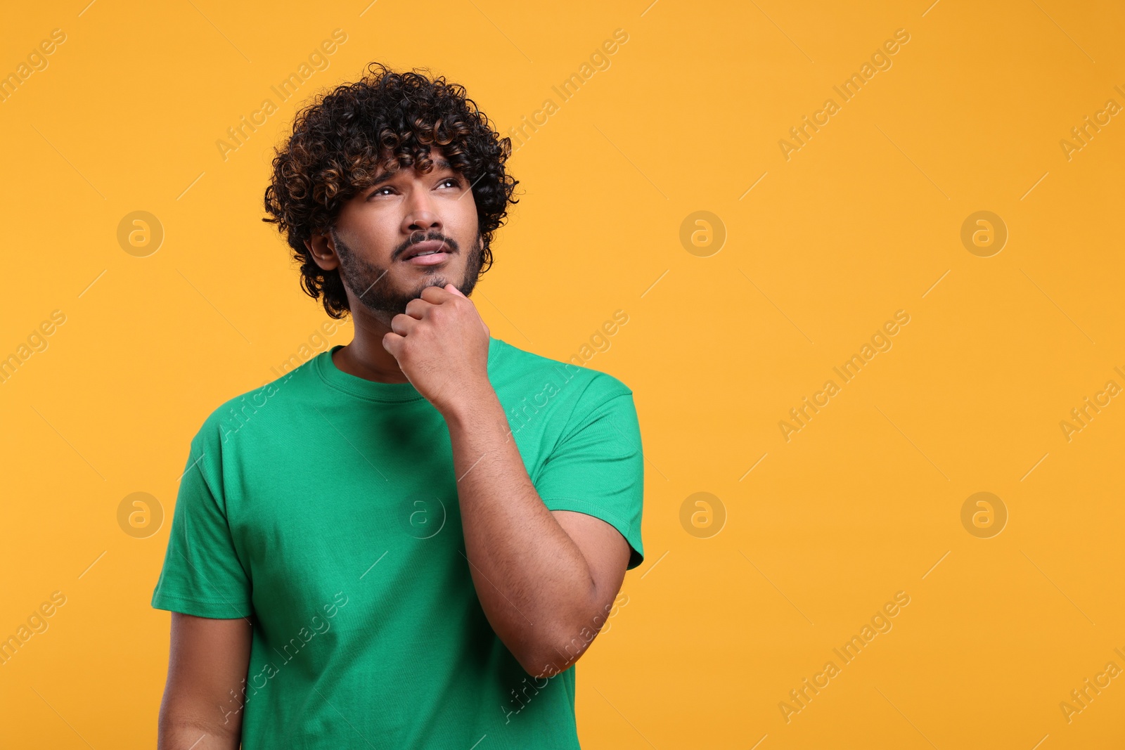 Photo of Handsome thoughtful man on yellow background, space for text