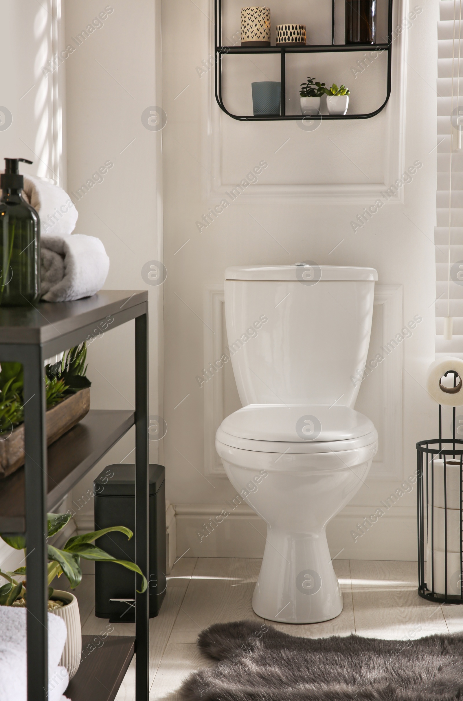 Photo of Modern toilet bowl in comfortable restroom. Interior design