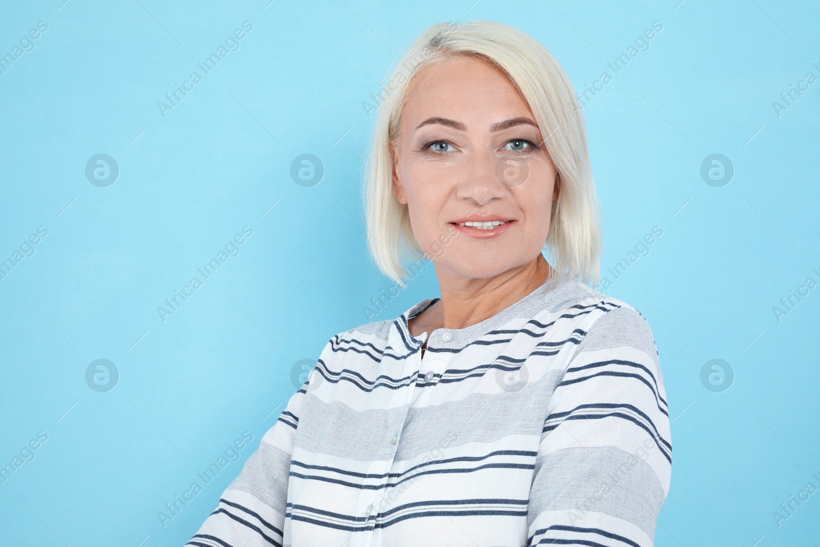 Photo of Portrait of mature woman with beautiful face on light blue background