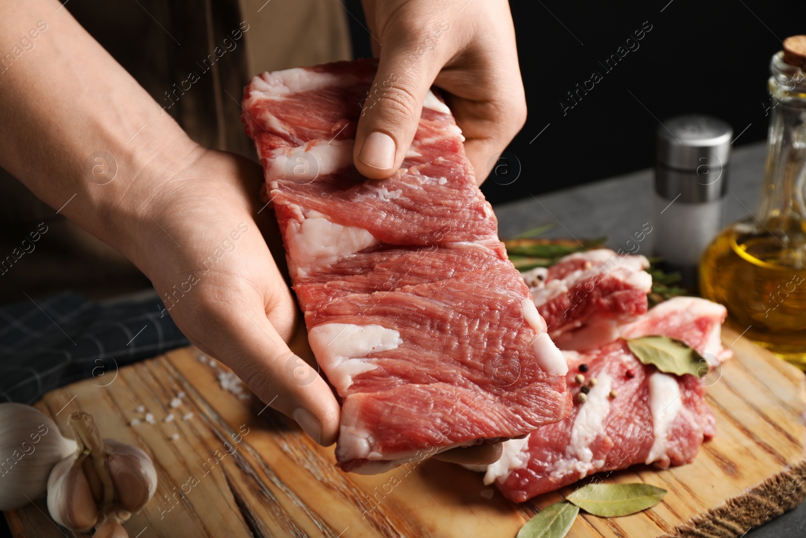 Photo of Man holding raw ribs at table, closeup