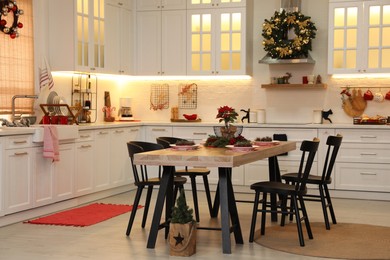 Cozy dining room interior with beautiful Christmas wreath and festive decor