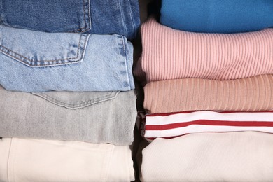 Photo of Different folded clothes as background, top view. Vertical storageclothing