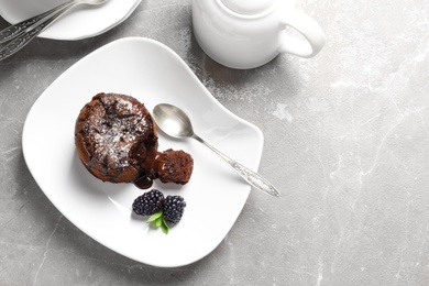 Plate of delicious fresh fondant with hot chocolate and blackberries on table, top view. Lava cake recipe