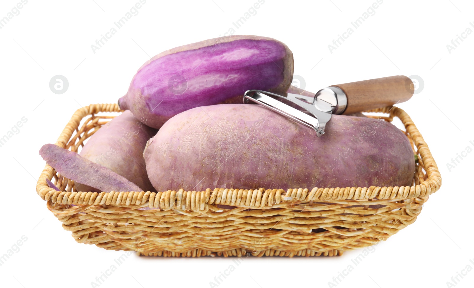 Photo of Purple daikon radishes and peeler in wicker basket isolated on white