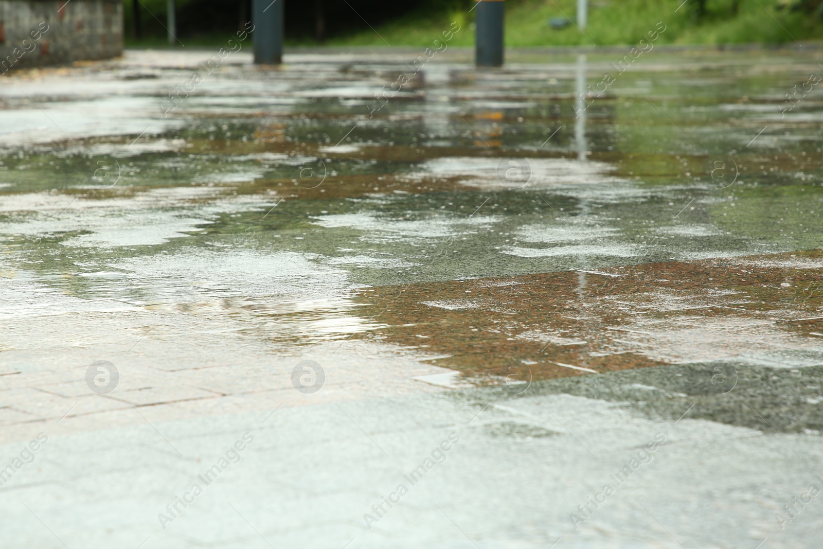 Photo of Puddles on street tiles after rain, closeup view