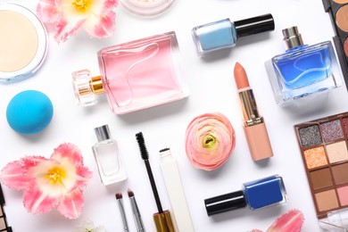 Photo of Flat lay composition with different makeup products and beautiful spring flowers on white background