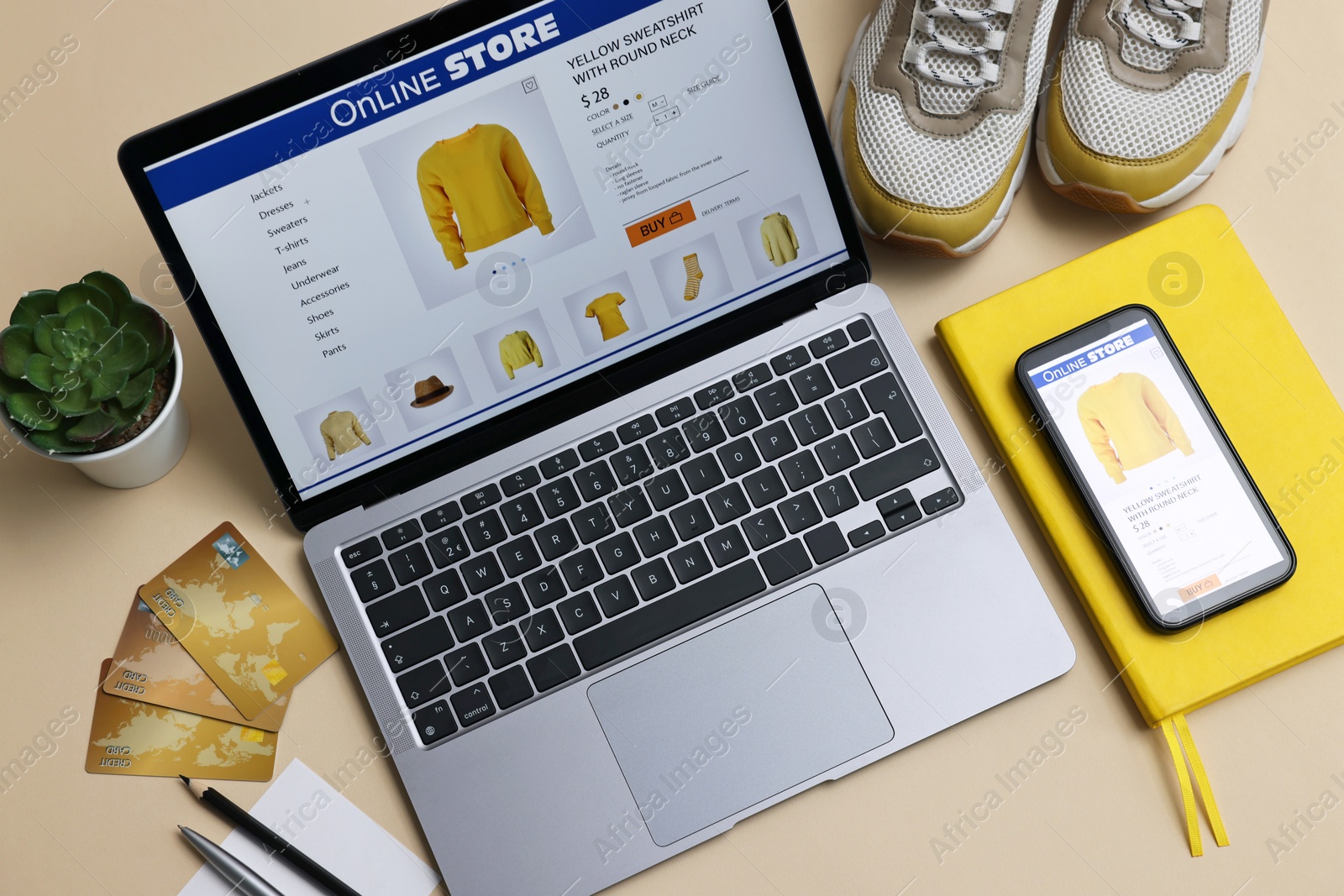 Photo of Online shopping. Composition with laptop on beige background, above view