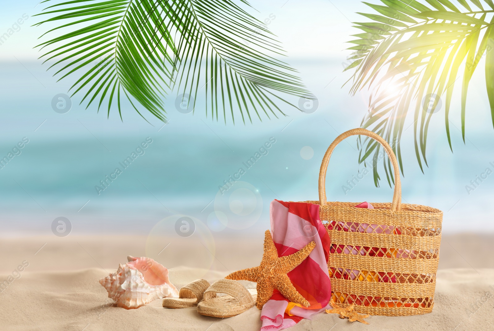 Image of Bag with accessories on sunny ocean beach, space for text. Summer vacation