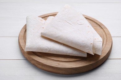 Delicious folded Armenian lavash on white wooden table, closeup