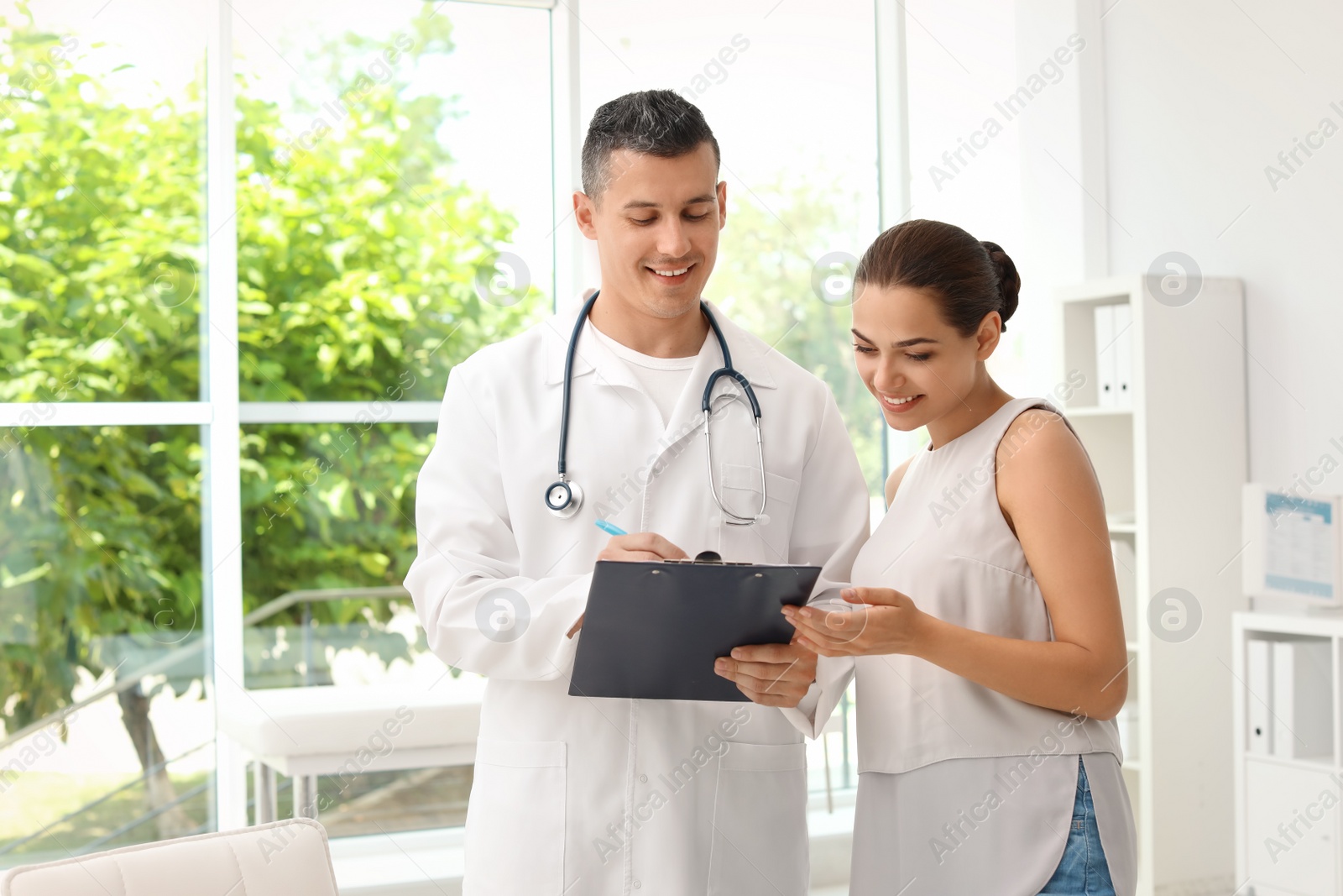 Photo of Young doctor speaking to patient in hospital