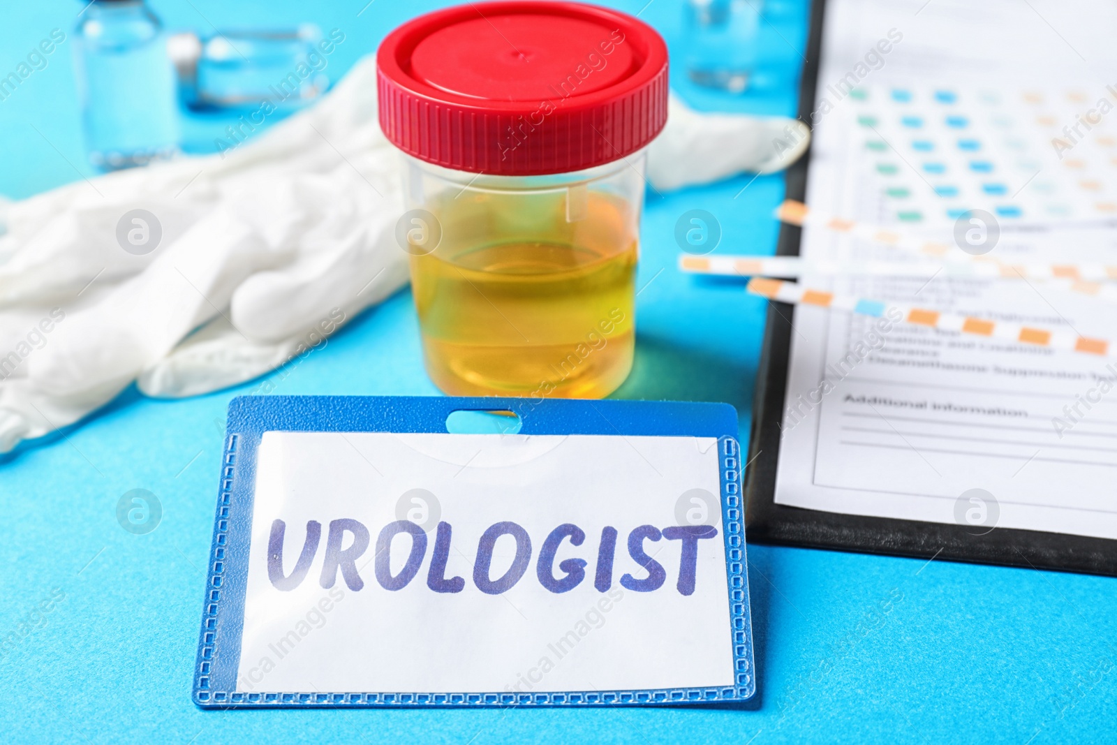 Photo of Urine sample and card with word UROLOGIST on table