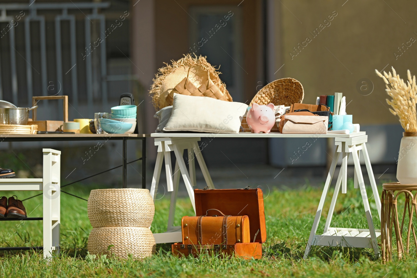 Photo of Small tables with many different items on garage sale in yard