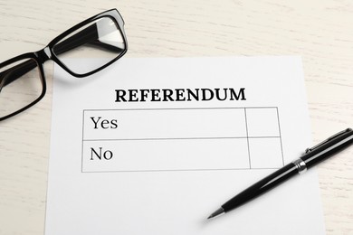 Photo of Referendum ballot with pen and glasses on white wooden table, flat lay