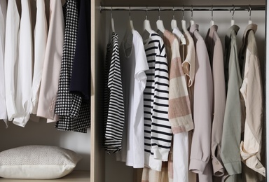 Photo of Wardrobe with different stylish clothes indoors, closeup