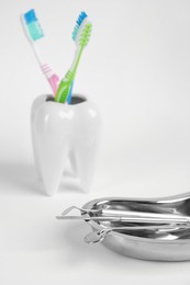 Photo of Kidney shaped tray with set of dentist's tools on light background, closeup. Space for text