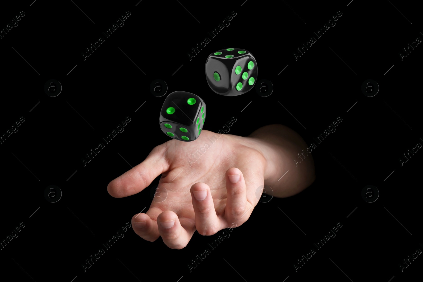 Image of Man throwing dice on black background, closeup