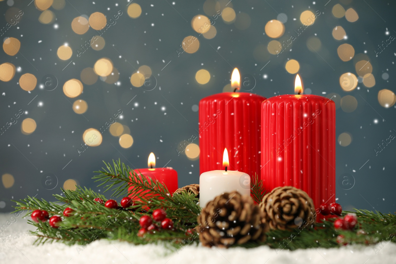 Photo of Snow falling on burning candles, fir branches and pine cones against blurred festive lights, space for text. Christmas eve