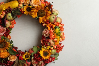 Beautiful autumnal wreath with flowers, berries and fruits on light grey background, top view. Space for text
