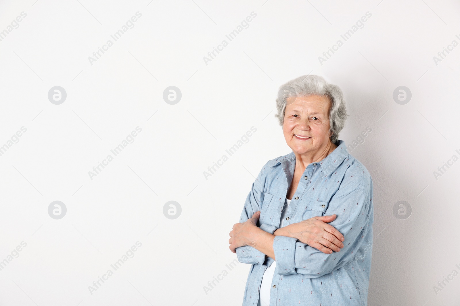 Photo of Portrait of grandmother in stylish clothes on light background, space for text