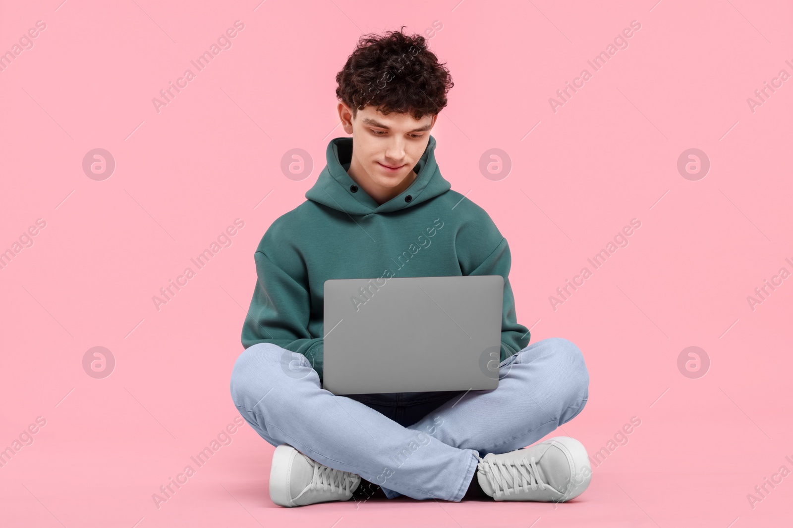 Photo of Portrait of student with laptop on pink background