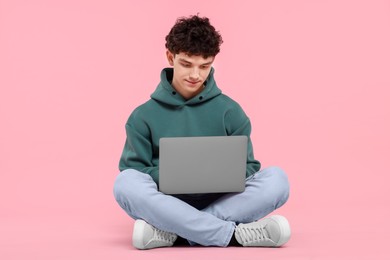 Portrait of student with laptop on pink background
