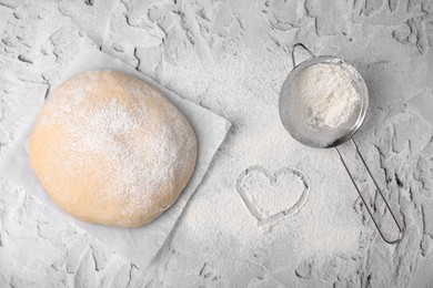 Fresh dough, sieve and flour on white textured table, flat lay