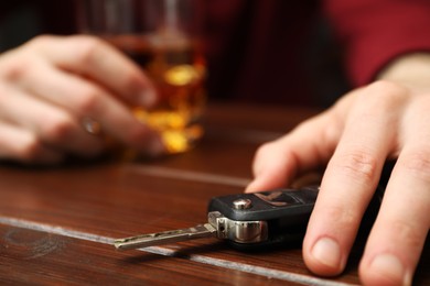 Photo of Drunk man reaching for car keys at table, closeup. Don't drink and drive concept