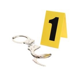 Photo of Handcuffs and crime scene marker with number one isolated on white